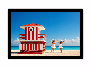 Minimal coastal beach scene with red lifeguard hut blue ocean and two women walking aesthetic Canvas Print