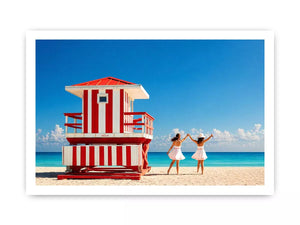 Minimal coastal beach scene with red lifeguard hut blue ocean and two women walking aesthetic Canvas Print