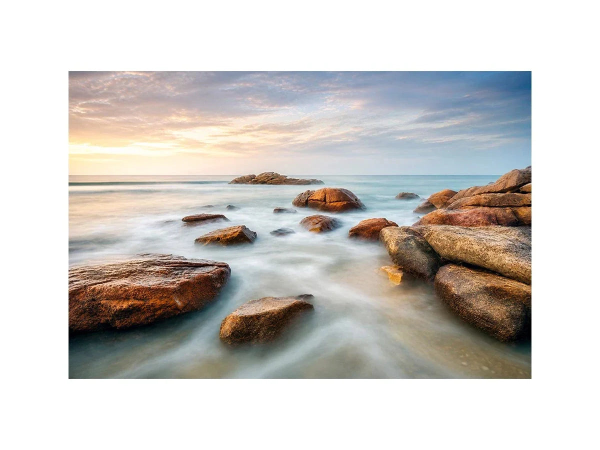 Ocean Whisper Horizon Serene coastal landscape wall art featuring smooth ocean waves, natural shoreline rocks, pastel sunrise