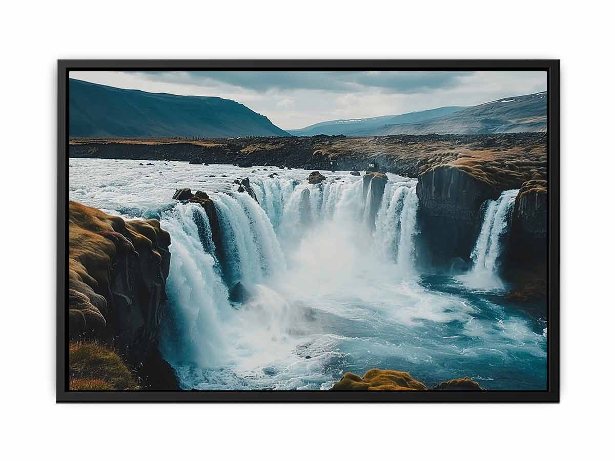 Dramatic Nordic waterfall canvas print with blue water and rugged cliffs for modern living room decor.