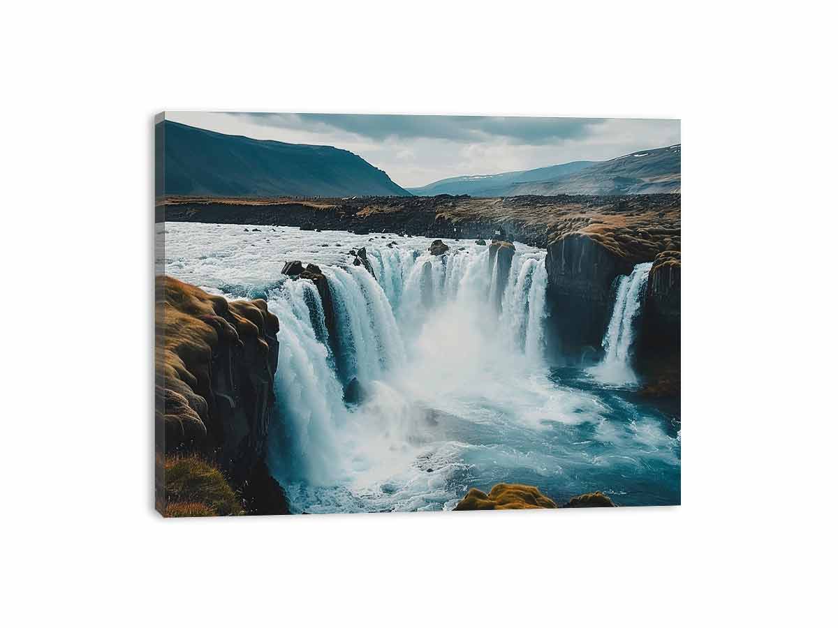 Dramatic Nordic waterfall canvas print with blue water and rugged cliffs for modern living room decor.
